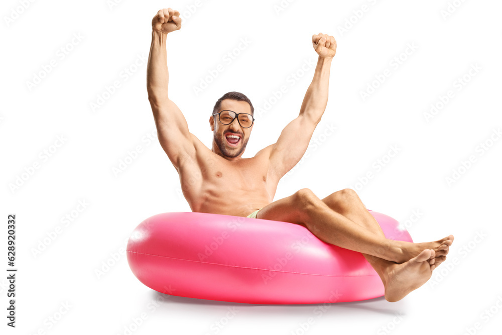 Handsome young man sitting on a swim ring and gesturing happiness Handsome young man sitting on a swim ring and gesturing happiness