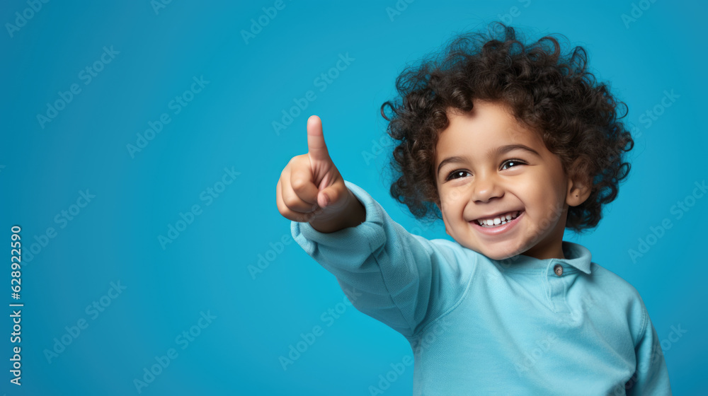 Child wearing casual clothes pointing with hand and finger to the side looking at the camera. Child wearing casual clothes pointing with hand and finger to the side looking at the camera.