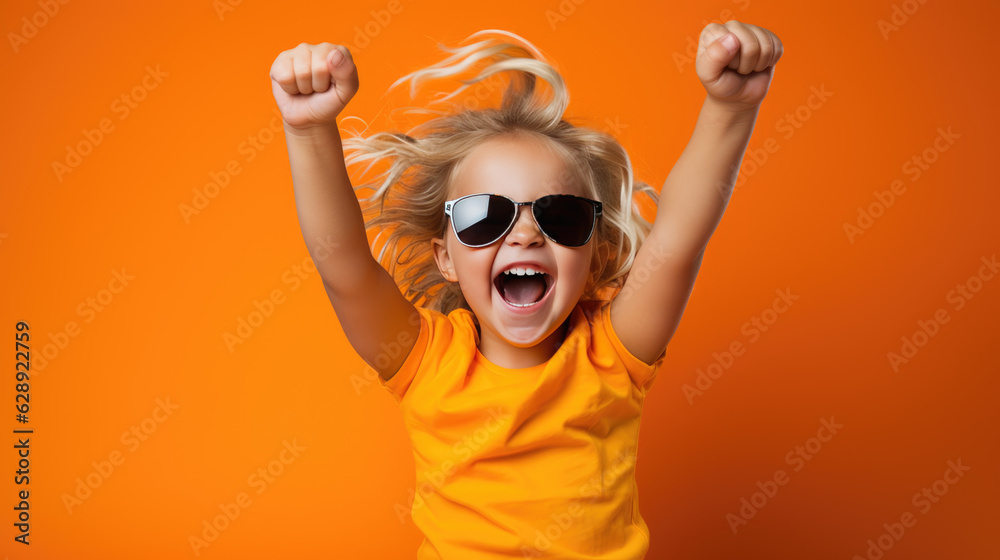 Small child shouts loudly while raising hands up in victory against isolated bright orange background. Small child shouts loudly while raising hands up in victory against isolated bright orange background.