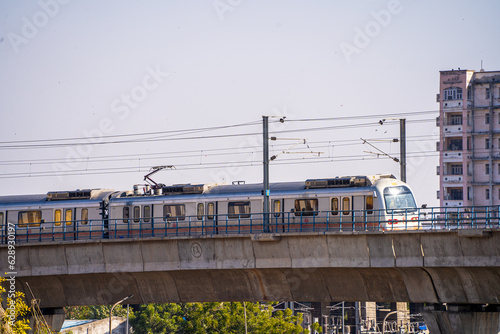 locked shot of metro crossing an overhead bridge at a rapid speed showing how the public tranport is improving in cities #628930197