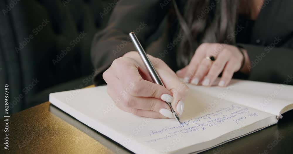 Woman writing with pen in a diary at home office. Work strategy notes of a busy businesswoman with remote work, job and career at her home. Concept of manual planning and remote work Woman writing with pen in a diary at home office. Work strategy notes of a busy businesswoman with remote work, job and career at her home. Concept of manual planning and remote work