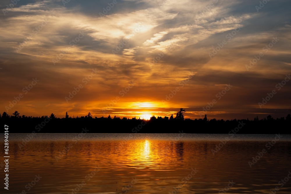 Stunning sunset over the horizon of a tranquil body of water, creating a picturesque scene