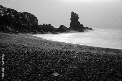 Idyllic beach scene in Reykjavik, Iceland featuring black sand and a foggy weather