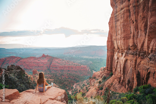 Little girl on the edge of a cliff at Cathedral Rock in Sedona, Arizona. View from Scenic Cathedral Rock in Sedona with blue sky in Arizona