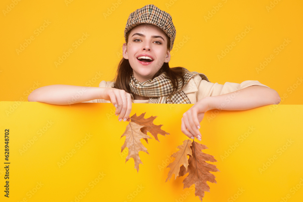 Studio portrait of young woman with autumn fall leaves.