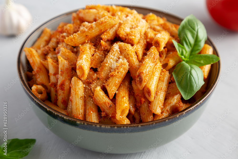 Homemade Tomato Pesto Pasta with Cheese and Basil in a Bowl, side view.