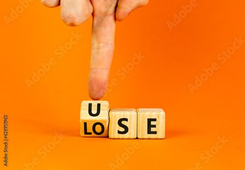 Use or lose symbol. Concept words Use or lose on wooden cubes. Businessman hand. Beautiful orange table orange background. Business Use or lose concept. Copy space.