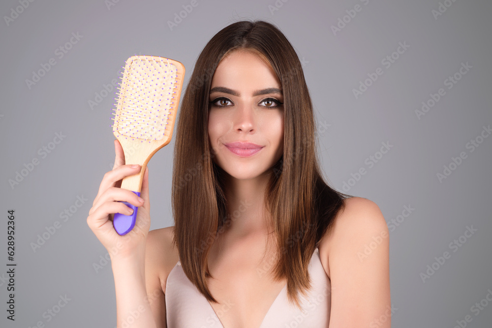 Beautiful woman with brush combing hair. Beauty girl with straight hair isolated on studio background. Woman hold hairbrush near face. Healthy hair. Hairstyle and hair care concept. Shiny hairs. Beautiful woman with brush combing hair. Beauty girl with straight hair isolated on studio background. Woman hold hairbrush near face. Healthy hair. Hairstyle and hair care concept. Shiny hairs.