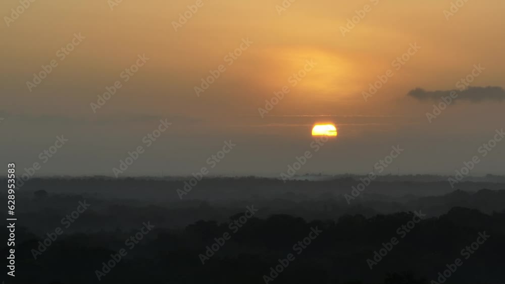 Golden sunrise shining in the sky over the wide forest Golden sunrise shining in the sky over the wide forest