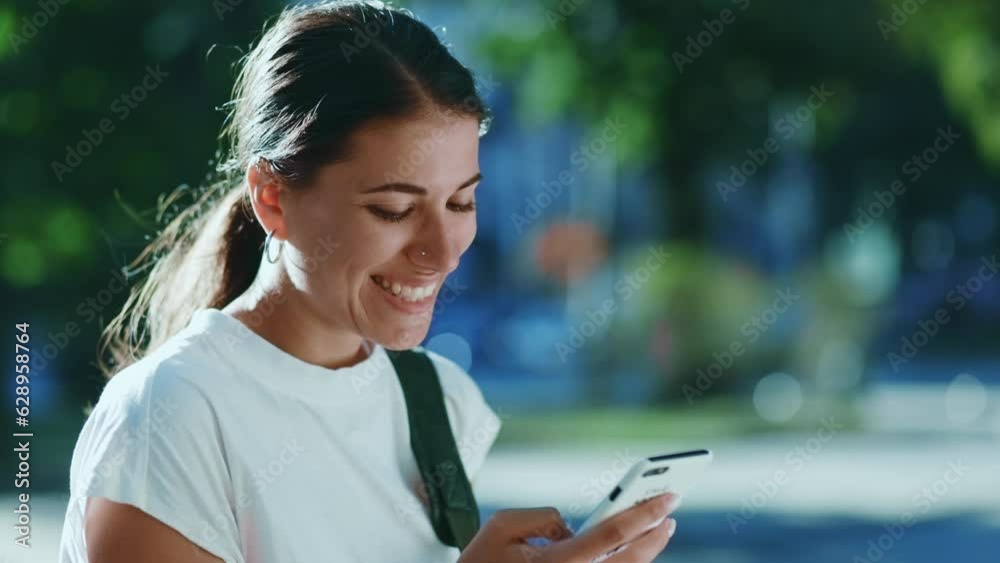 Young caucasian female walking and looking at her phone with a smile Young caucasian female walking and looking at her phone with a smile