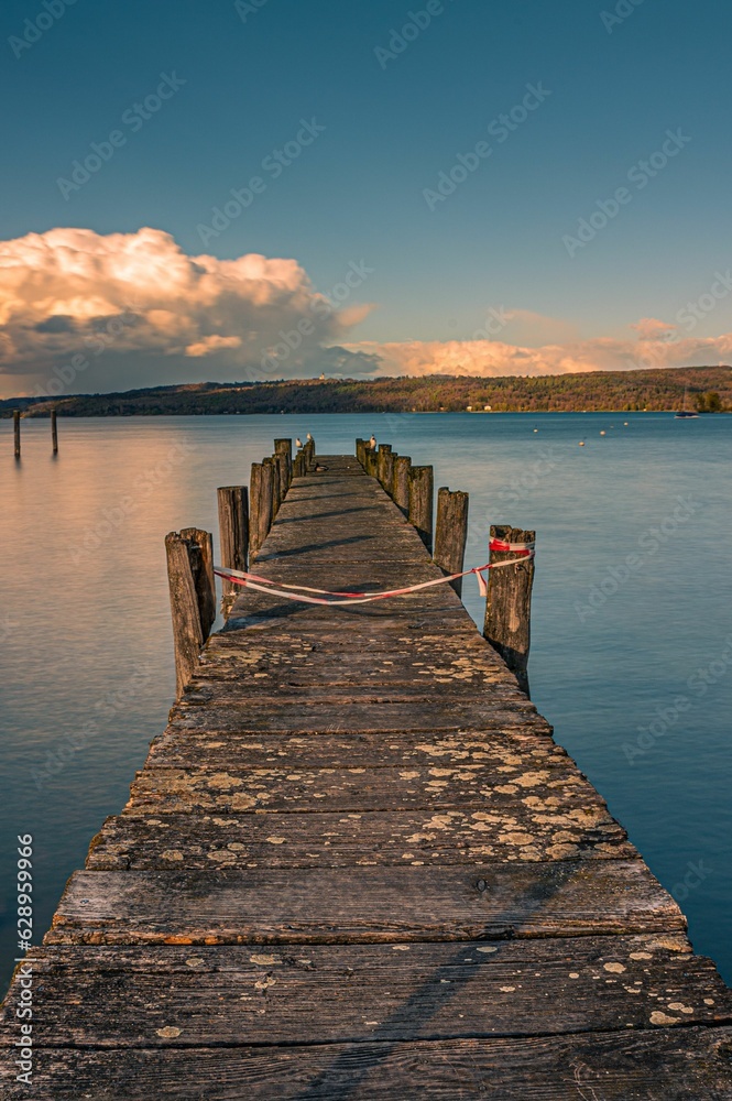 Wooden dock over a lake during the golden hour in Bavaria, Germany