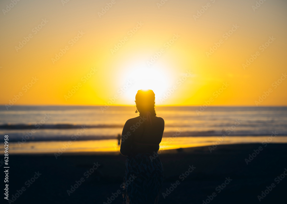 silhouette of a person on the beach at sunset