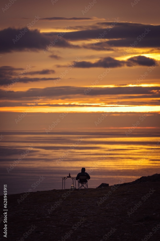 a person admires the sunset at the north cape