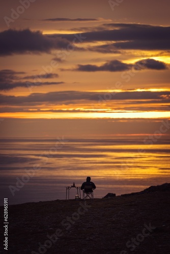 a person admires the sunset at the north cape