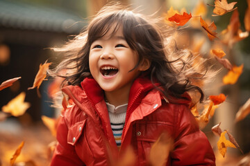 close up of little asian girl child playing in autumn fall leaves red jacket