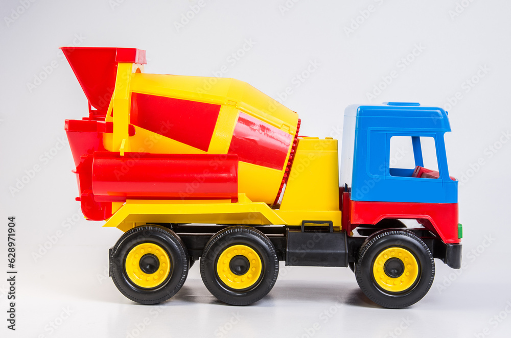 Multi-colored plastic toy trucks for children's games on a white background. Concrete mixer.