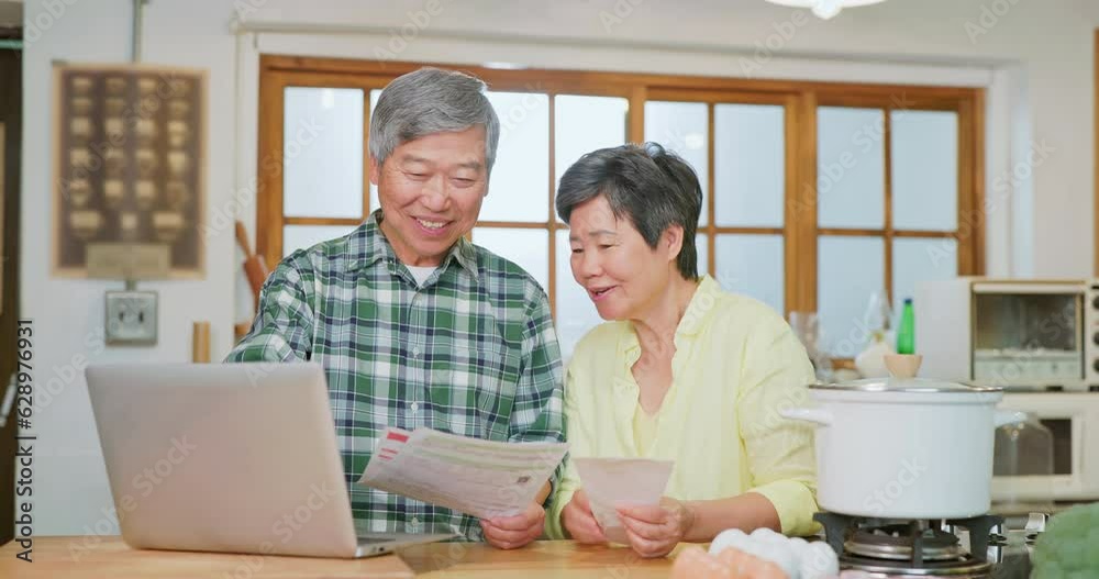 Asian elderly couple look bills Asian elderly couple look bills