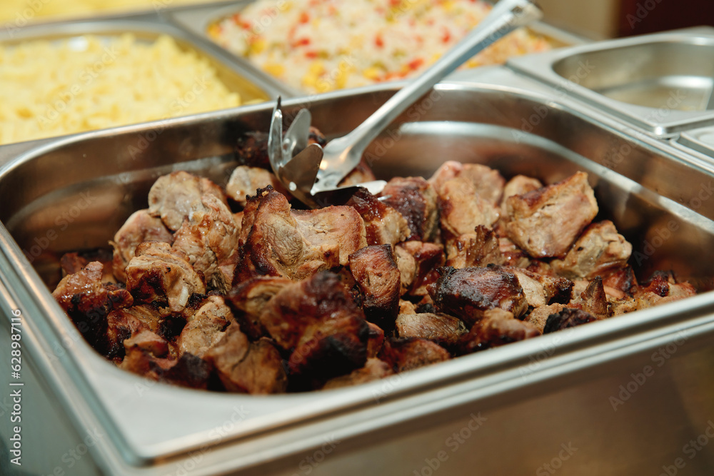 European buffet catering food. Fried meat in a metal tray. Celebration party concept. Selective focus. Close-up. European buffet catering food. Fried meat in a metal tray. Celebration party concept. Selective focus. Close-up.