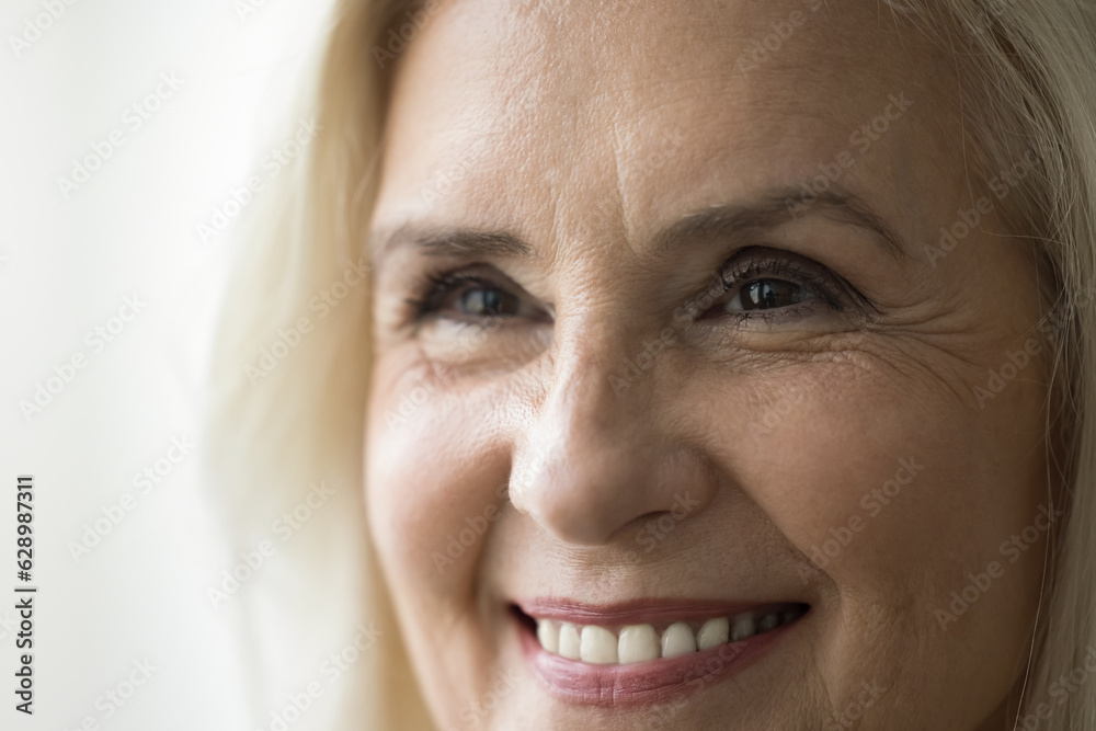 Face of happy old retired woman with make up, looking away, smiling with perfect white teeth. Close up facial portrait of senior model promoting, beauty, dental care, eyesight Face of happy old retired woman with make up, looking away, smiling with perfect white teeth. Close up facial portrait of senior model promoting, beauty, dental care, eyesight