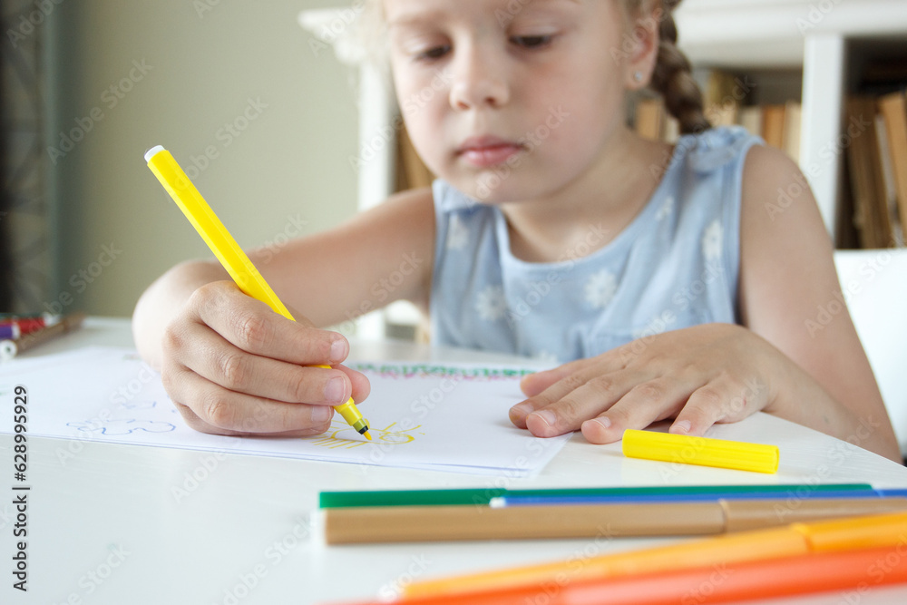 Cute child drawing a picture with colored felt-tip pens. Concept of hobby or education Cute child drawing a picture with colored felt-tip pens. Concept of hobby or education