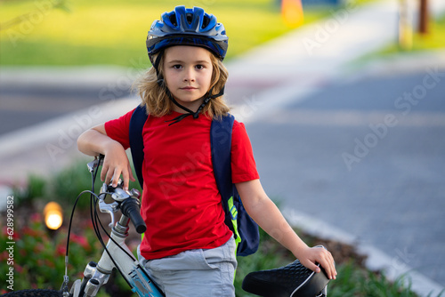 Child on bicycle. Boy in a helmet riding bike. Little cute caucasian boy in safety helmet riding bike in city park. Child first bike. Kid outdoors summer activities. Kid on bicycle. Boy ride a bike.