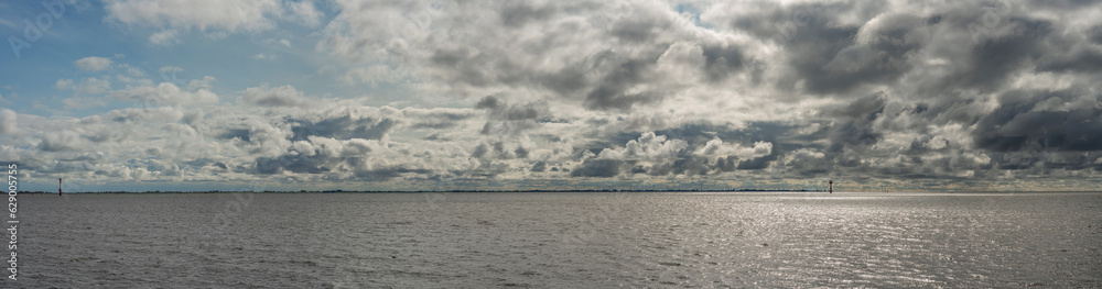 Clouds in the sky over the ocean near Bremerhaven in Germany, North Sea Panorama, Storm on the Ocean, travel vibes, oceanic skyline view, big dark clouds over the water