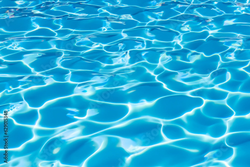 Vibrant blue water surface with captivating sunlit reflections, closeup view of a swimming pool