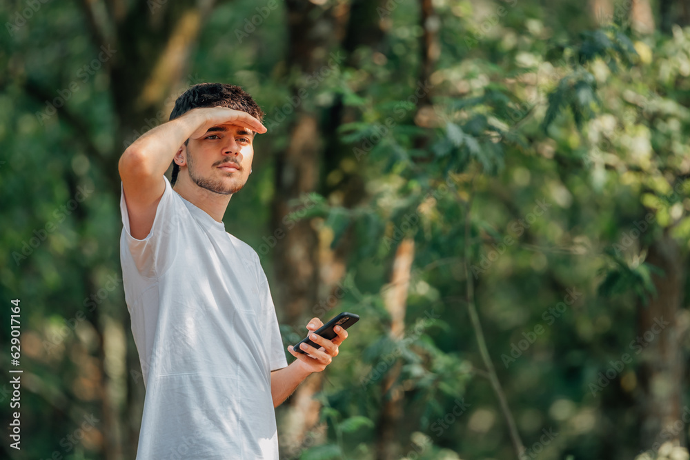 young sportsman with mobile phone in the forest young sportsman with mobile phone in the forest