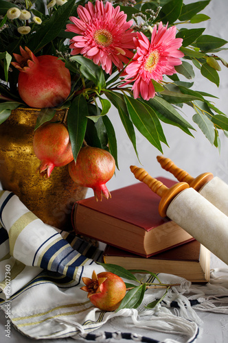 Bouquet of flowers and fruits of pomegranate, shofar (horn) and Torah on a wooden table, the concept of the Jewish new year - Rosh Hashanah. photo