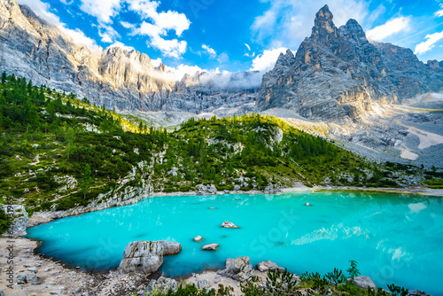 Beautiful view on turquoise Sorapis lake and with dito di dio in the background in the evening. Lake Sorapis, Dolomites, Belluno, Italy, Europe.