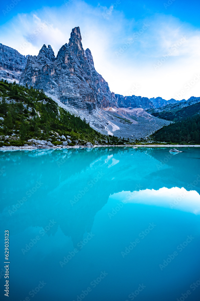 Beautiful reflections on turquoise Sorapis lake and with dito di dio in the background in the evening. Lake Sorapis, Dolomites, Belluno, Italy, Europe.