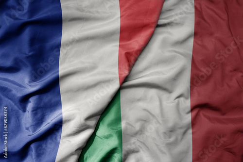 big waving realistic national colorful flag of france and national flag of italy .