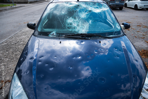 Obraz na płótnie hail damage to car. damaged hood and windshield