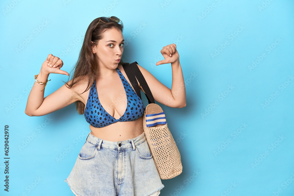 Beach-ready woman with bikini, sunglasses and bag feels proud and self confident, example to follow. Beach-ready woman with bikini, sunglasses and bag feels proud and self confident, example to follow.