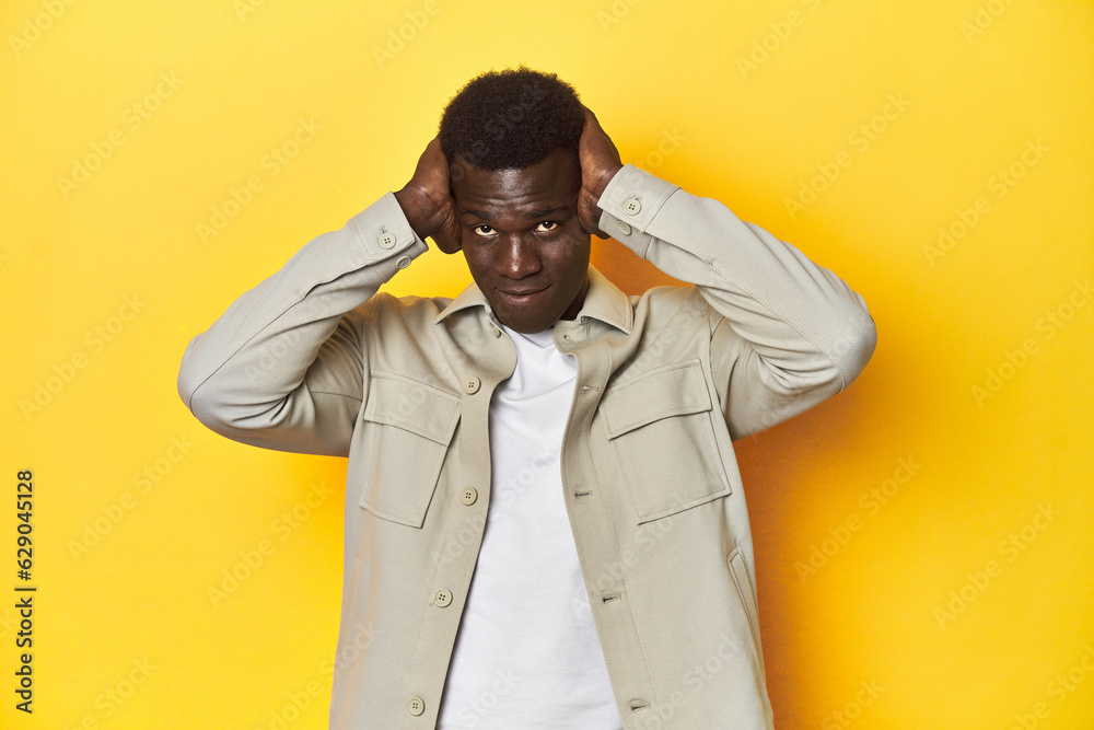 Stylish young African man on vibrant yellow studio background, screaming, very excited, passionate, satisfied with something. Stylish young African man on vibrant yellow studio background, screaming, very excited, passionate, satisfied with something.