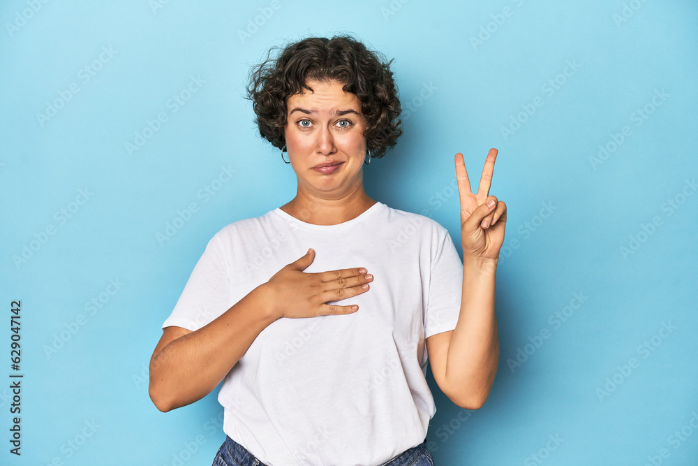 Young Caucasian woman with short hair taking an oath, putting hand on chest. Young Caucasian woman with short hair taking an oath, putting hand on chest.