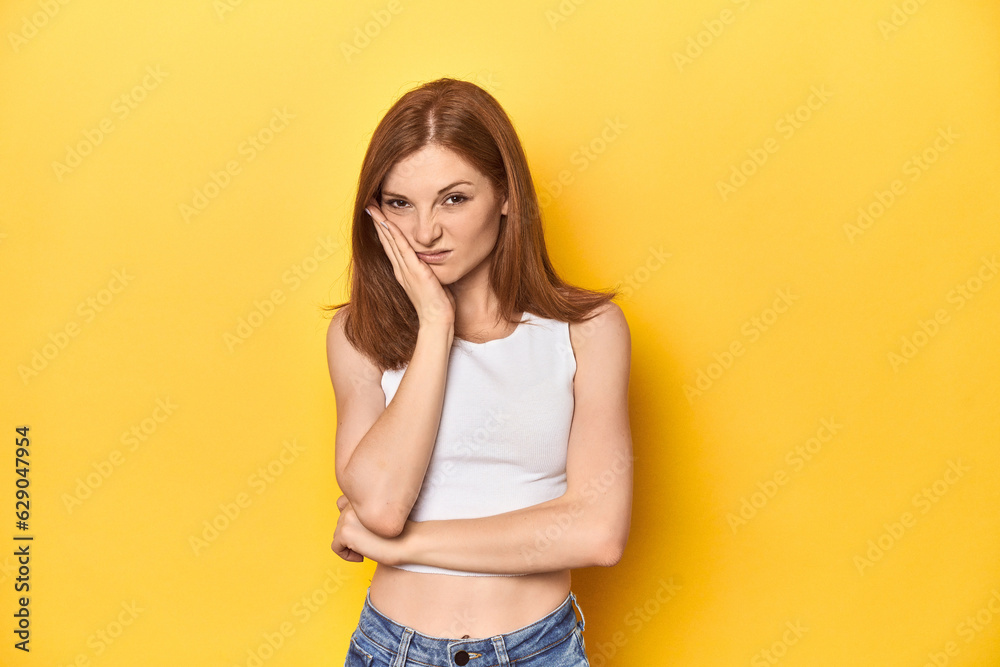 Redhead in white tank top, relaxed studio pose who is bored, fatigued and need a relax day. Redhead in white tank top, relaxed studio pose who is bored, fatigued and need a relax day.