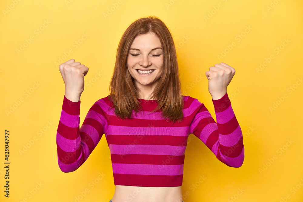 Redhead in pink-red striped shirt, casual look cheering carefree and excited. Victory concept. Redhead in pink-red striped shirt, casual look cheering carefree and excited. Victory concept.