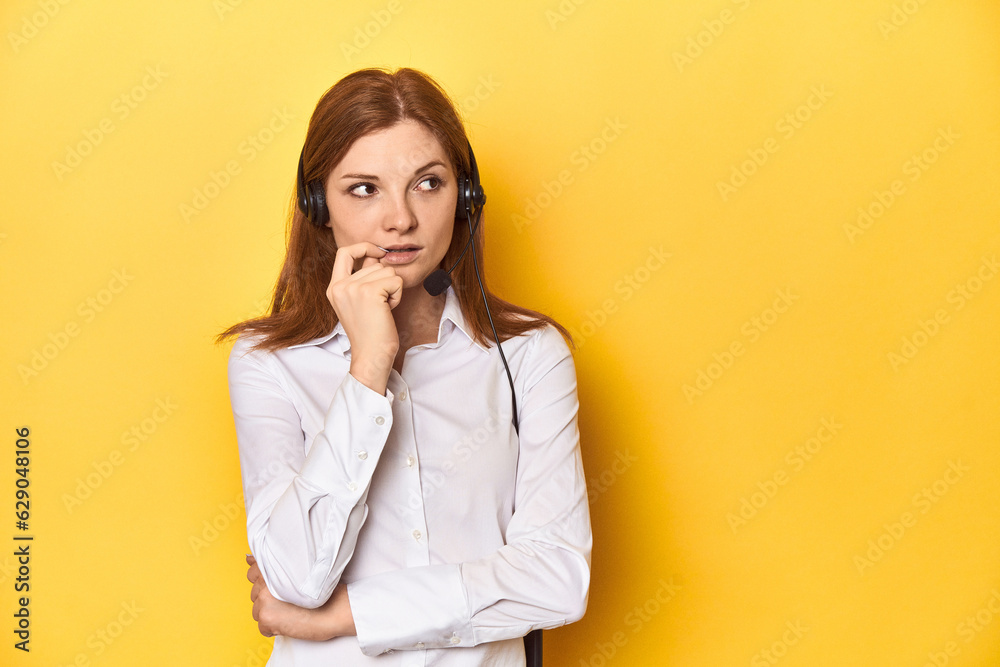 Call center redhead in white shirt, headphones on relaxed thinking about something looking at a copy space. Call center redhead in white shirt, headphones on relaxed thinking about something looking at a copy space.