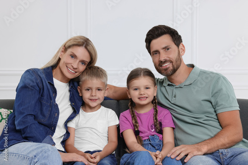 Portrait of happy family with children on sofa at home