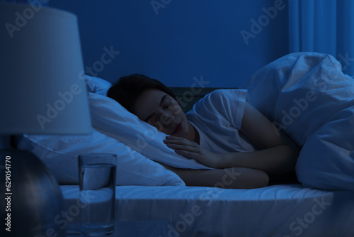 Beautiful young woman sleeping in bed at night photo