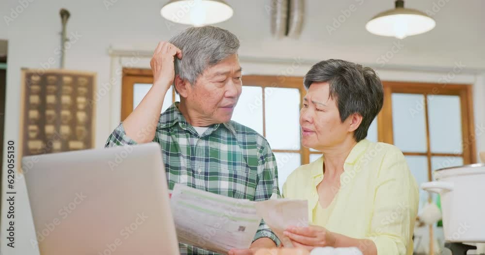 Asian elderly couple look bills