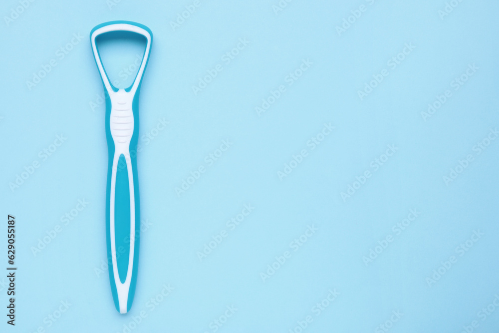 Tongue cleaner on light blue background, top view. Space for text Tongue cleaner on light blue background, top view. Space for text