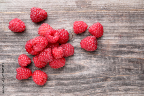 Tasty ripe raspberries on wooden table, top view. Space for text