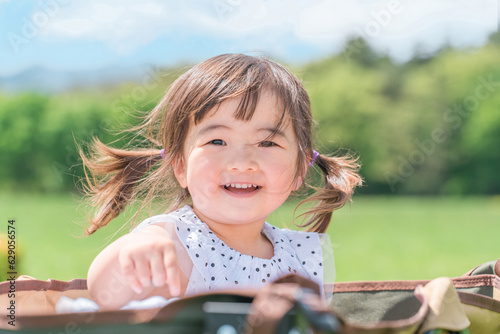 公園でキャリーカートに乗って遊ぶ女の子（子供・幼児・少女）
