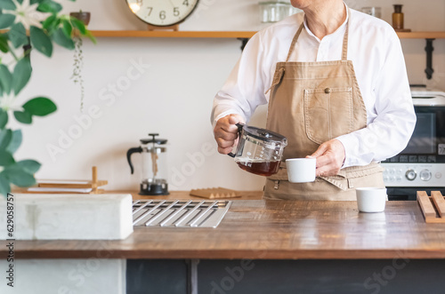 家・カフェのキッチンでコーヒー・紅茶・お茶を淹れるグルメなアジア人高齢者男性  © buritora