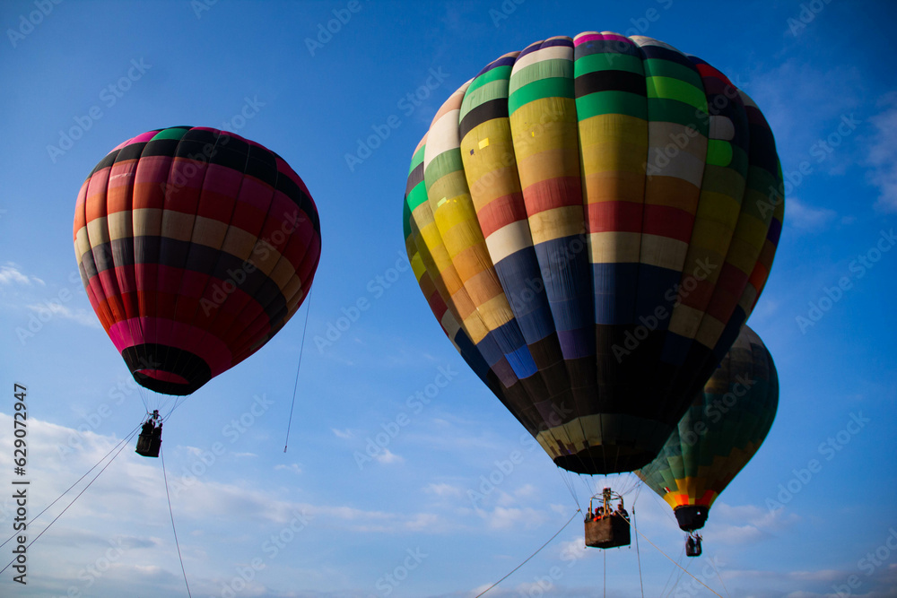Obraz premium three colorful hot air balloons, darning the blue sky