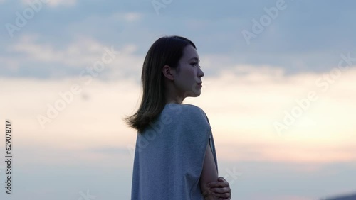 夕暮れの海にいる女性