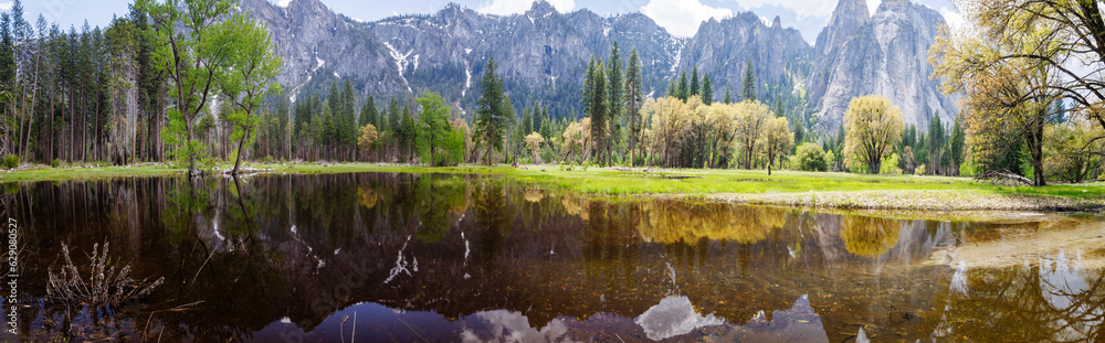 Panorama view of Mountains reflecting on flood water pond from Northside Drive in Yosemite Valley, Yosemite National Park, California, USA in May of 2023
