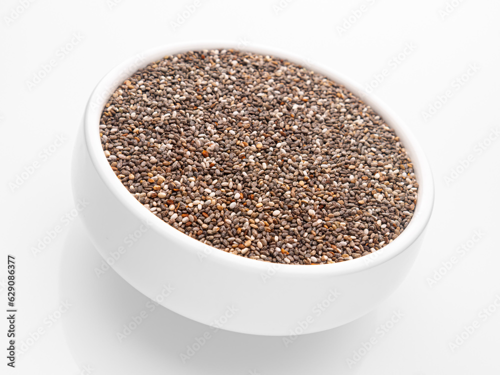 Chia seeds in a deep white bowl on a white background. Isolate. Incline. Close-up. Selective focus. Chia seeds in a deep white bowl on a white background. Isolate. Incline. Close-up. Selective focus.
